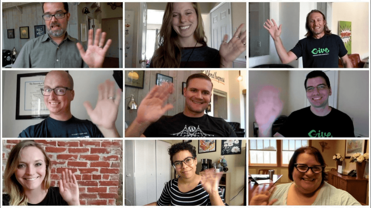 A grid of nine people waving at their cameras from different rooms. 