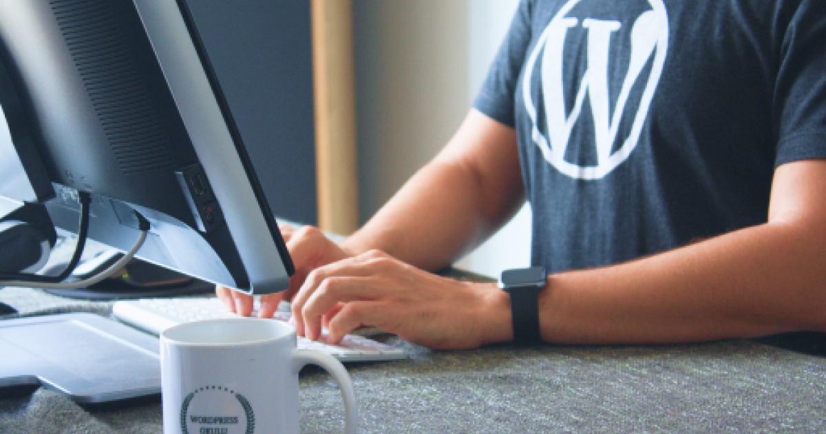 Man building a website while wearing a WordPres shirt.