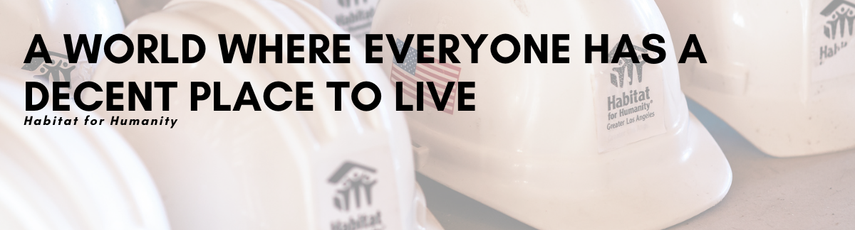 Several Habitat for Humanity hardhats sit in the background with black text overlaid, sharing Habitat's Vision Statement: A world where everyone has a decent place to live.